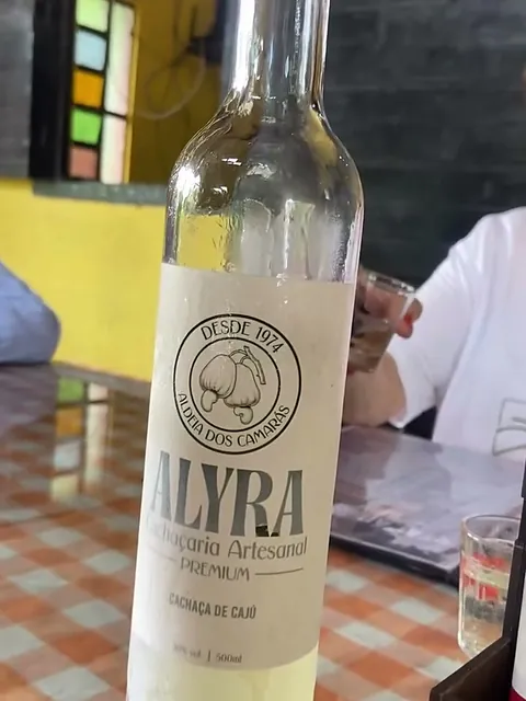 Garrafa de ALYRA gelada na mesa da Estação BBQ, em Aldeia