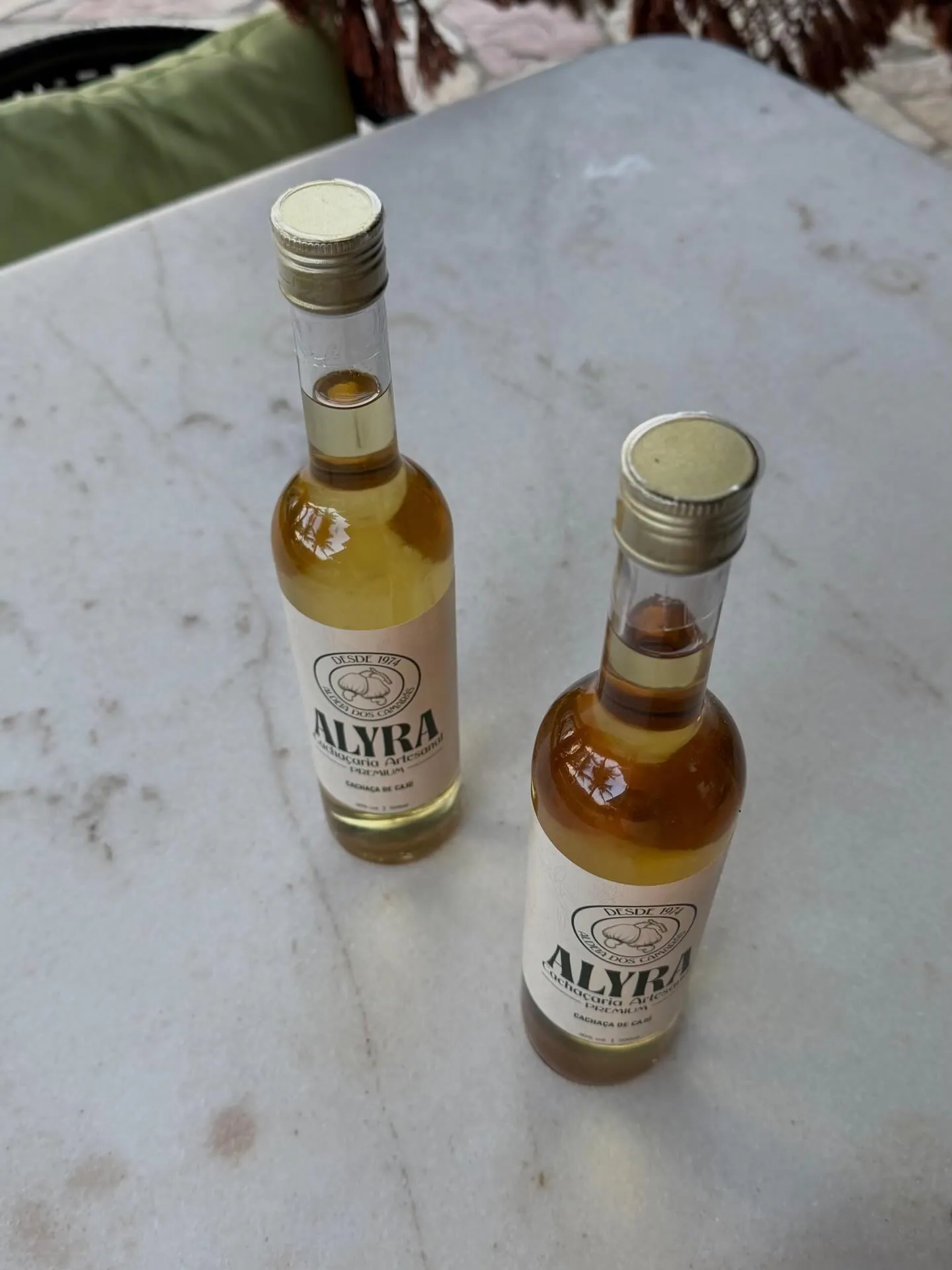 Duas garrafas de 500 ml da ALYRA vistas de cima, sobre mármore
