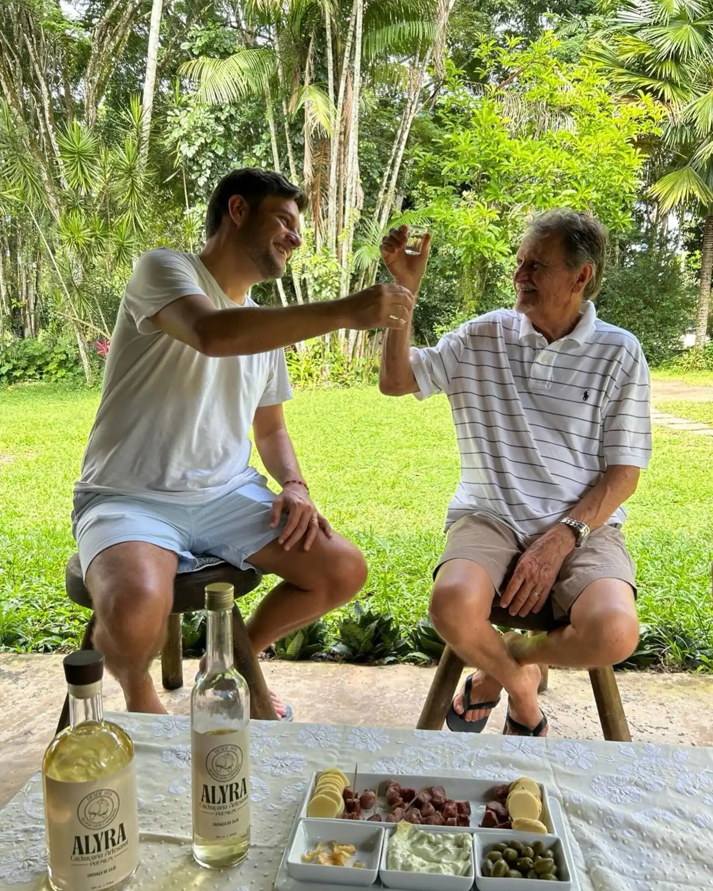 Pai e filho brindam com ALYRA no jardim, em Aldeia